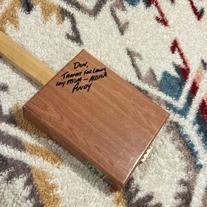 Electric strum box ukulele. Has writing on the back.